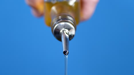 male hand pouring olive oil out of the bottle.