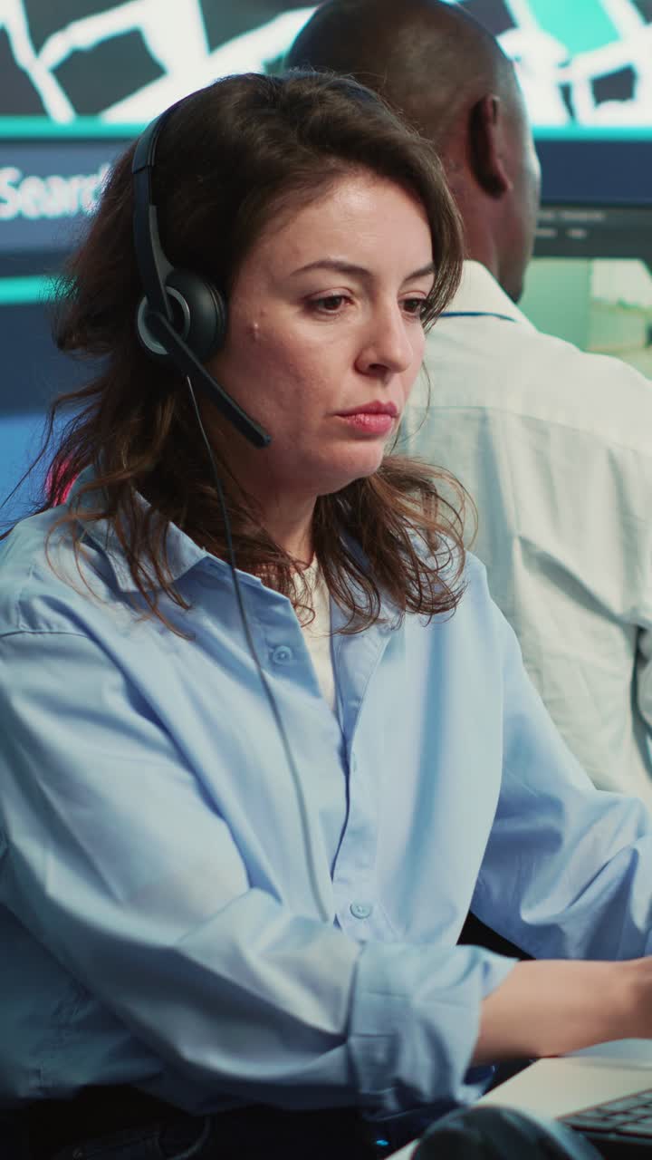 Fokusert kvinne med headset som jobber på et kundesenterkontor