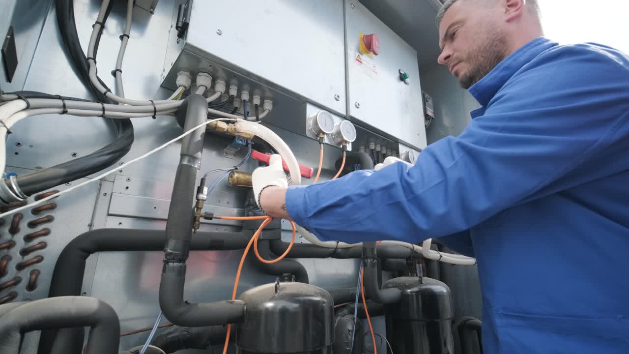 il tecnico controlla le linee elettriche dello scambiatore di calore con le pinze di corrente