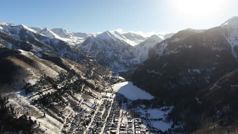 Filmische-Luftdrohne-Von-Oben,-Blick-Auf-Das-Skigebiet-Telluride-Mountain-In-Der-Innenstadt-Von-Colorado,-Mit-Malerischer-Berglandschaft-Und-Historischen-Gebäuden,-Frühes-Sonnenlicht,-Mitten-Im-Winter,-Rückwärtsschwenken,-Offenbaren-Bewegung