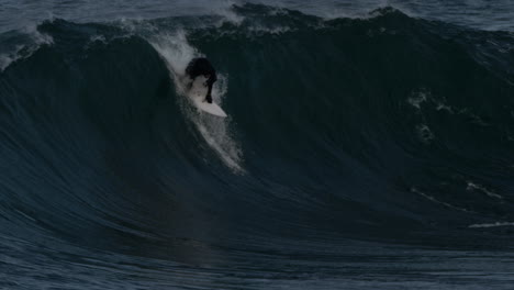 Surfer-paddles-quickly-to-pop-up-and-drop-in-on-heavy-face-of-wave-wiping-out-in-slow-motion-going-over-the-falls