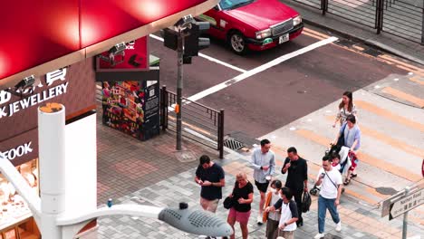 pedestrians navigate a crosswalk in hong kong