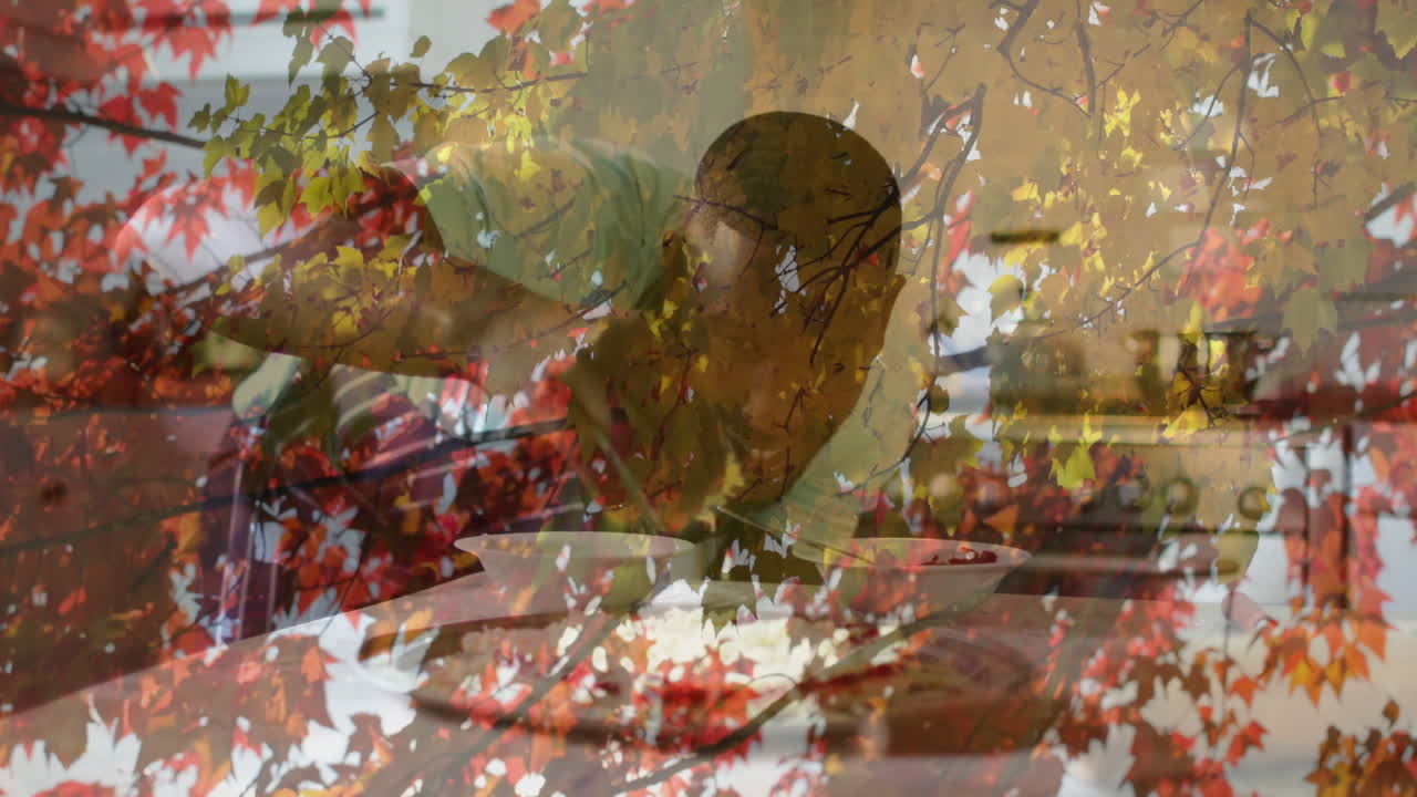 Animation of autumn leaves overlaying scene with child eating meal at table