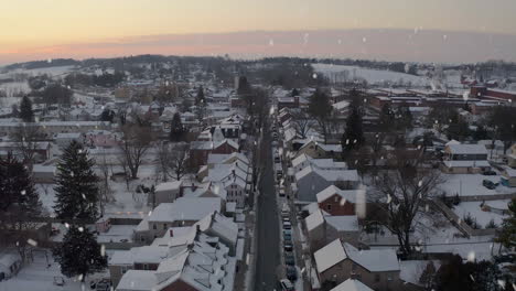 Snow-falls-on-town-at-sunrise,-sunset