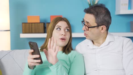 Father-and-daughter-looking-at-the-phone-together.