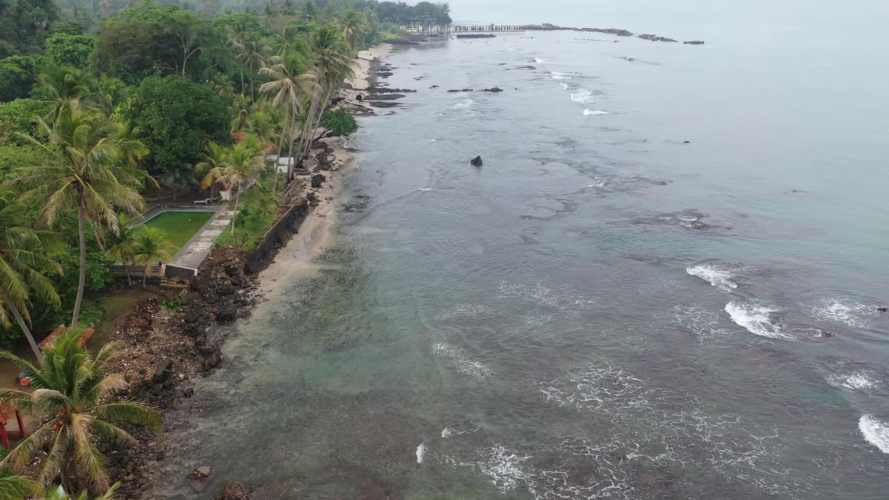 Costa tropicale con molo e relitto di nave