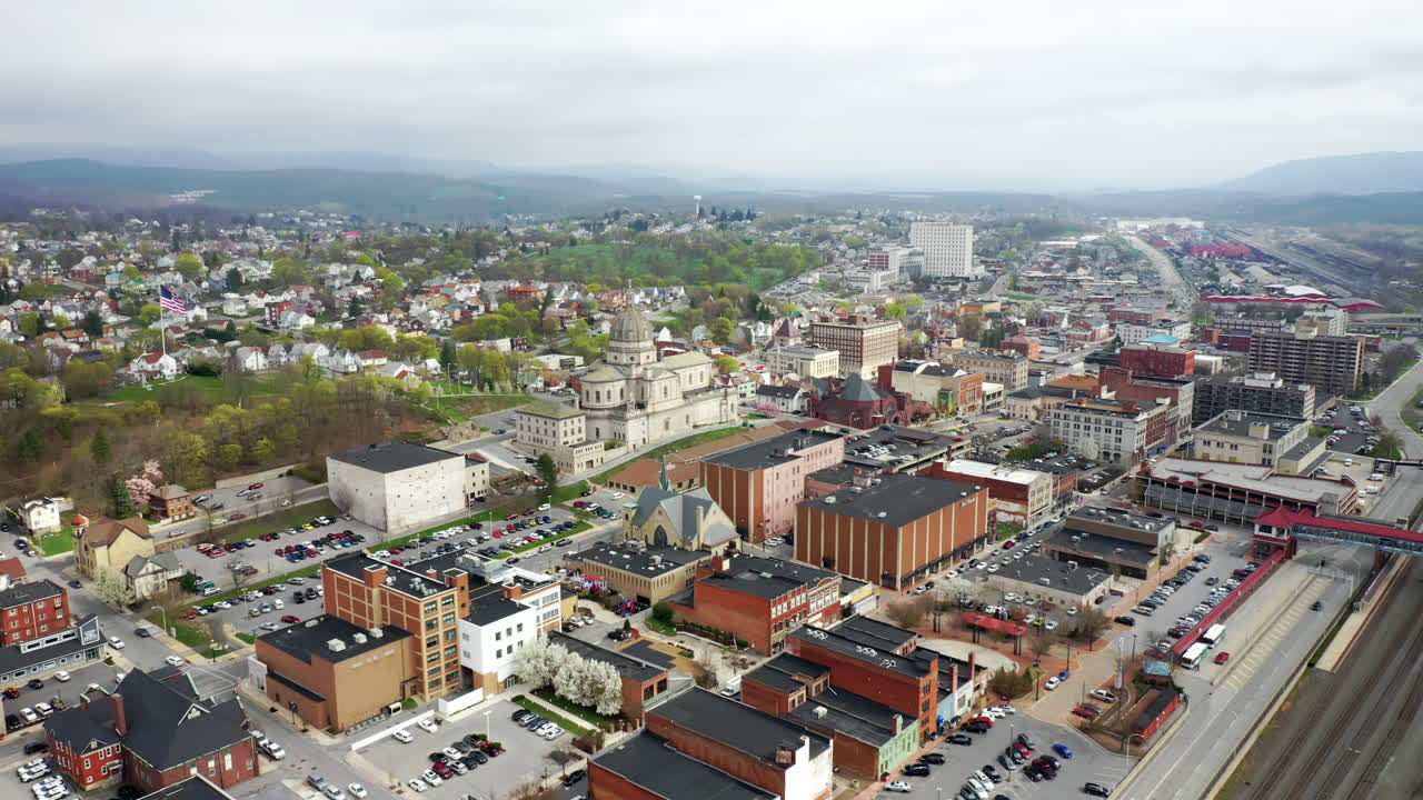 drones aéreos sobrevolando el pequeño centro rural de altoona pensilvania en el verano mostrando el ferrocarril y la gran iglesia