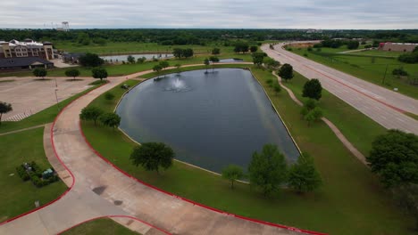 imágenes aéreas de un estanque frente a la iglesia de valley creek en flowermound texas
