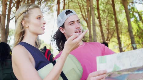 pareja sosteniendo un mapa y apuntando a la distancia 4k