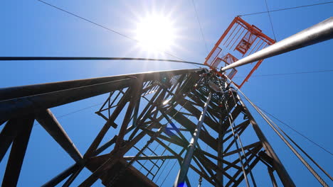 standing at the foot of the metal tower used for drilling oil or gas. low angle view on the derrick at resource producing site.