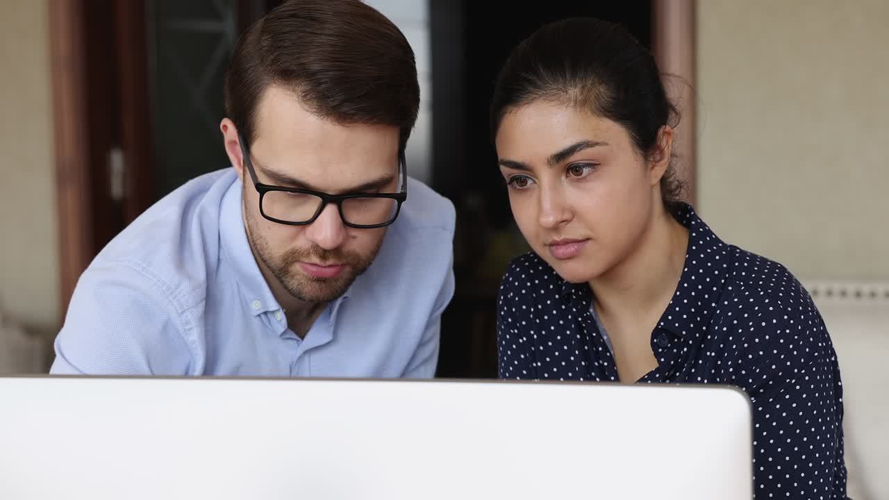 un hombre de negocios serio, un experto, consulta a una joven india, una interna en el lugar de trabajo.