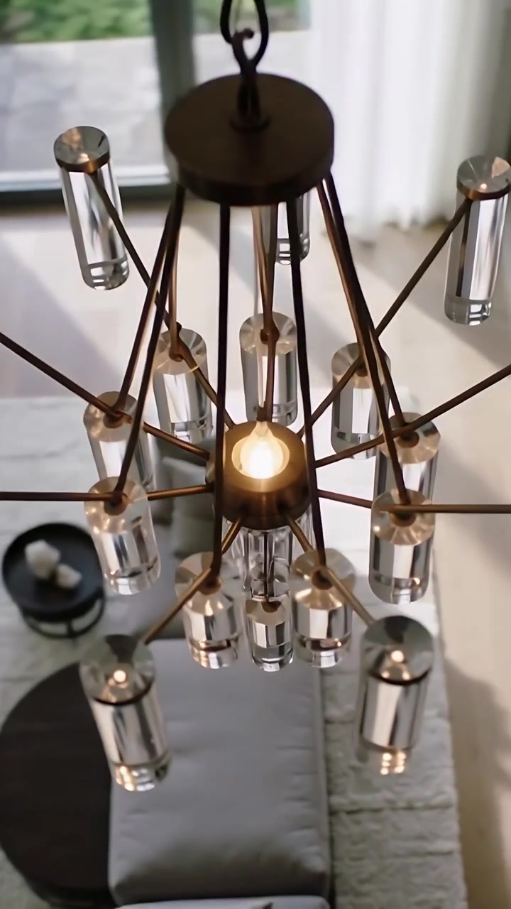 Video verticale: La telecamera si allontana rivelando una lampadina accesa del lampadario, prismi di luce sopra il divano e la finestra.
