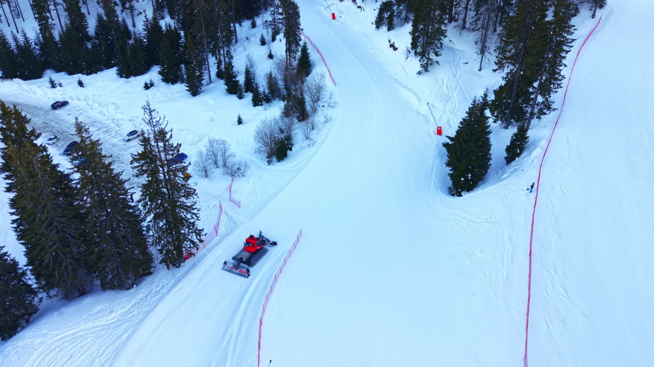 Vista aerea di un gatto delle nevi che prepara una pista da sci in montagna d'inverno