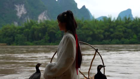 chinese girl fixes long hair on traditional fishermen scene