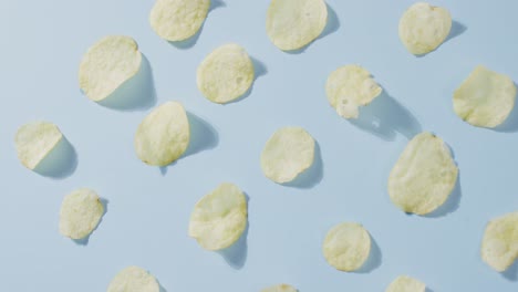 Close-up-of-potato-chips-with-copy-space-on-blue-surface