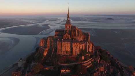 drone flying toward and over mont saint-michel at sunset, normandy in france