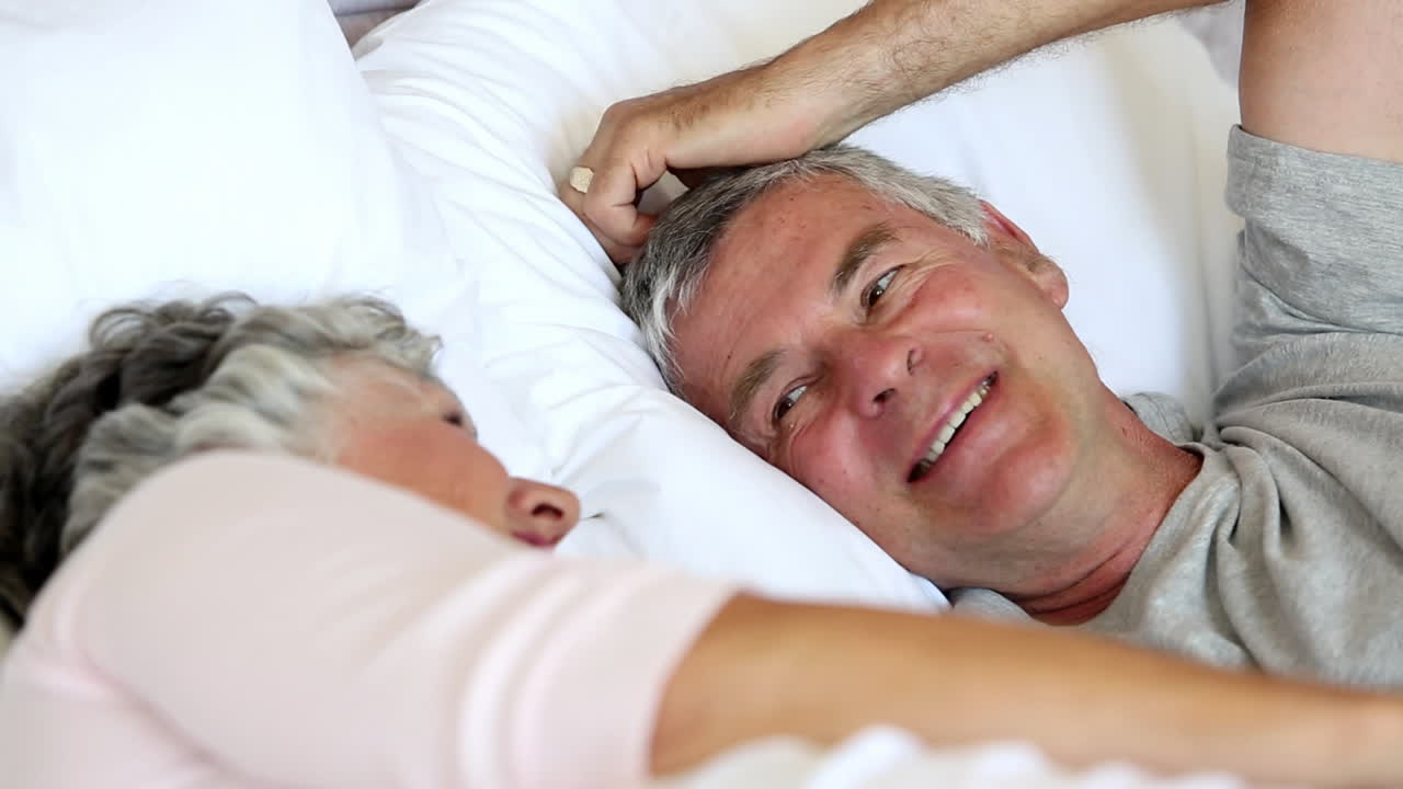 una pareja madura hablando y riendo juntos.