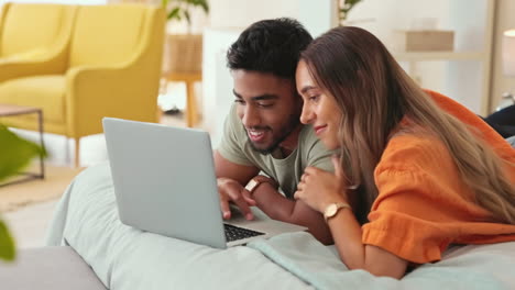 laptop, video and a couple lying on a bed