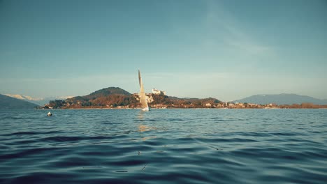 Punto-De-Vista-De-ángulo-Bajo-De-Proa-De-Barco-Navegando-En-El-Lago-Maggiore-Con-Castillo-En-Segundo-Plano