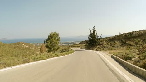 Conduciendo-Por-La-Carretera-Asfaltada-Durante-El-Verano-En-Cos-Isla-Griega,-Grecia