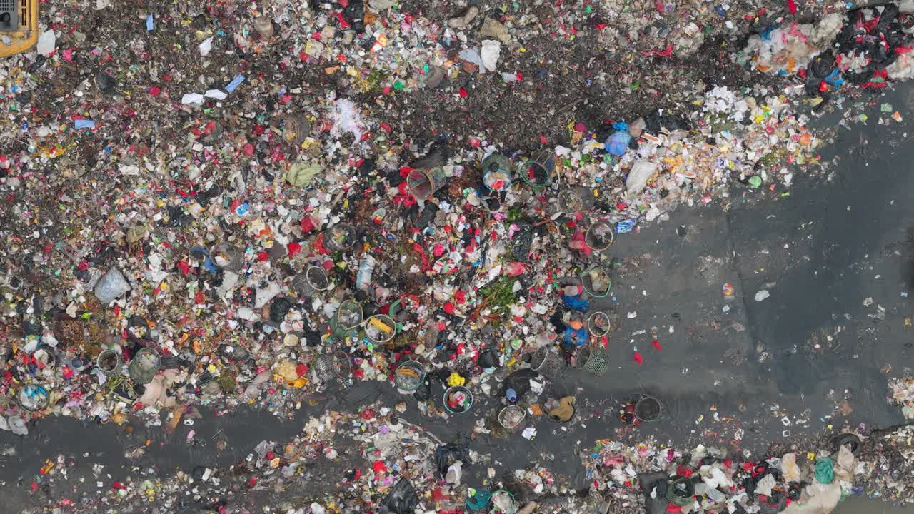 Vista aerea dall'alto di una discarica con camion della spazzatura che scarica rifiuti