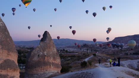 Globos-Aerostáticos-Llenan-El-Cielo-Matutino-En-Goreme,-Empujan-Hacia-Adelante-Sobre-El-Impresionante-Paisaje-De-Capadocia