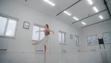 ballerina practicing in a white dance studio