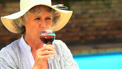 woman tasting red wine outdoors