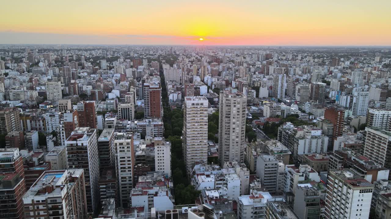 sale volando sobre los edificios del barrio de belgrano al atardecer con un sol brillante en el horizonte, buenos aires, argentina