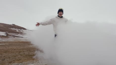 reveal shot of man standing info dense vapor cloud coming from steam vent