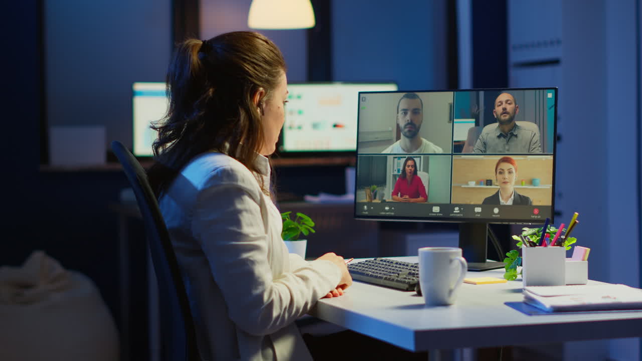 Employee discussing with partners online using webcam at night