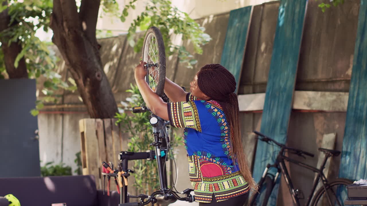 mujer separando la rueda dañada de una bicicleta