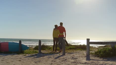 Rear-view-young-couple-standing-on-the-beach-4k