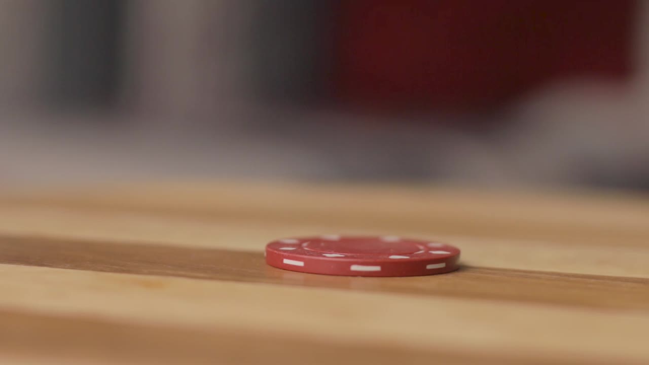 pan right close up of poker chip being spun by man