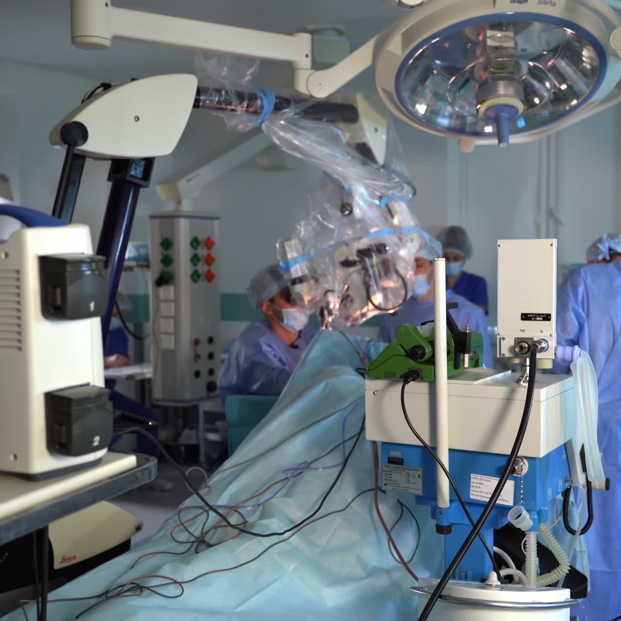 Surgery room equipped by the innovative technological devices. Surgeon team conducting operation at the backdrop