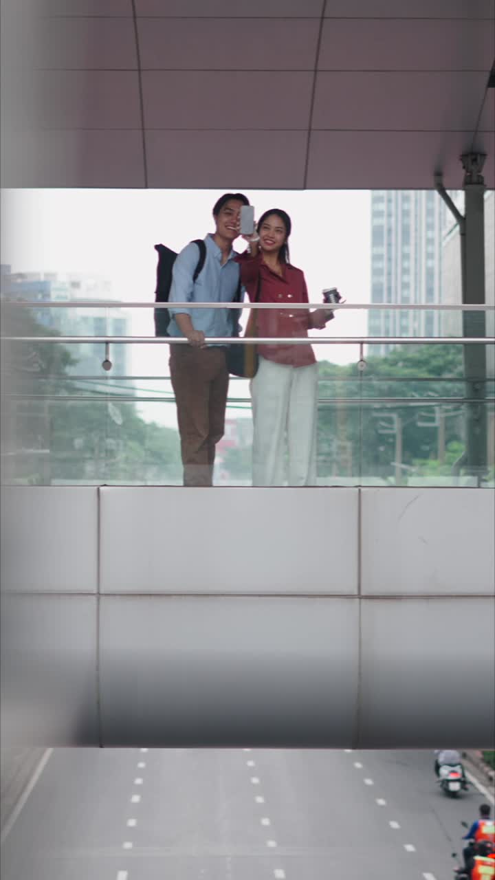 Couple taking selfie on pedestrian bridge