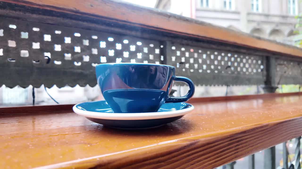 木製のテーブルに置かれた青いコーヒーカップ
