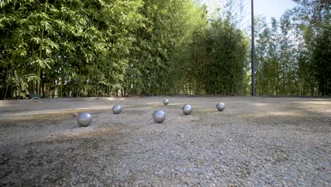 Pétanque-Ballspielplatz-In-Südfrankreich-Mit-Metallkugeln-Nach-Einer-Runde,-Orbit-Um-Schuss