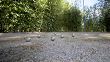 cancha de petanca en el sur de francia con bolas de metal después de una ronda, orbita alrededor del tiro