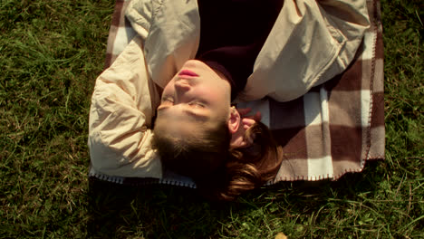 woman relaxing on a blanket in the grass
