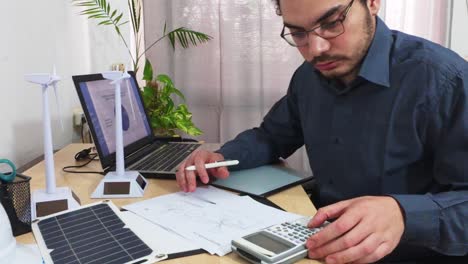 engineer using a calculator for wind turbine design specifications