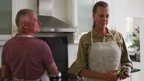 Pareja-Mayor-Caucásica-Usando-Delantales-Cocinando-Juntos-En-La-Cocina-De-Casa