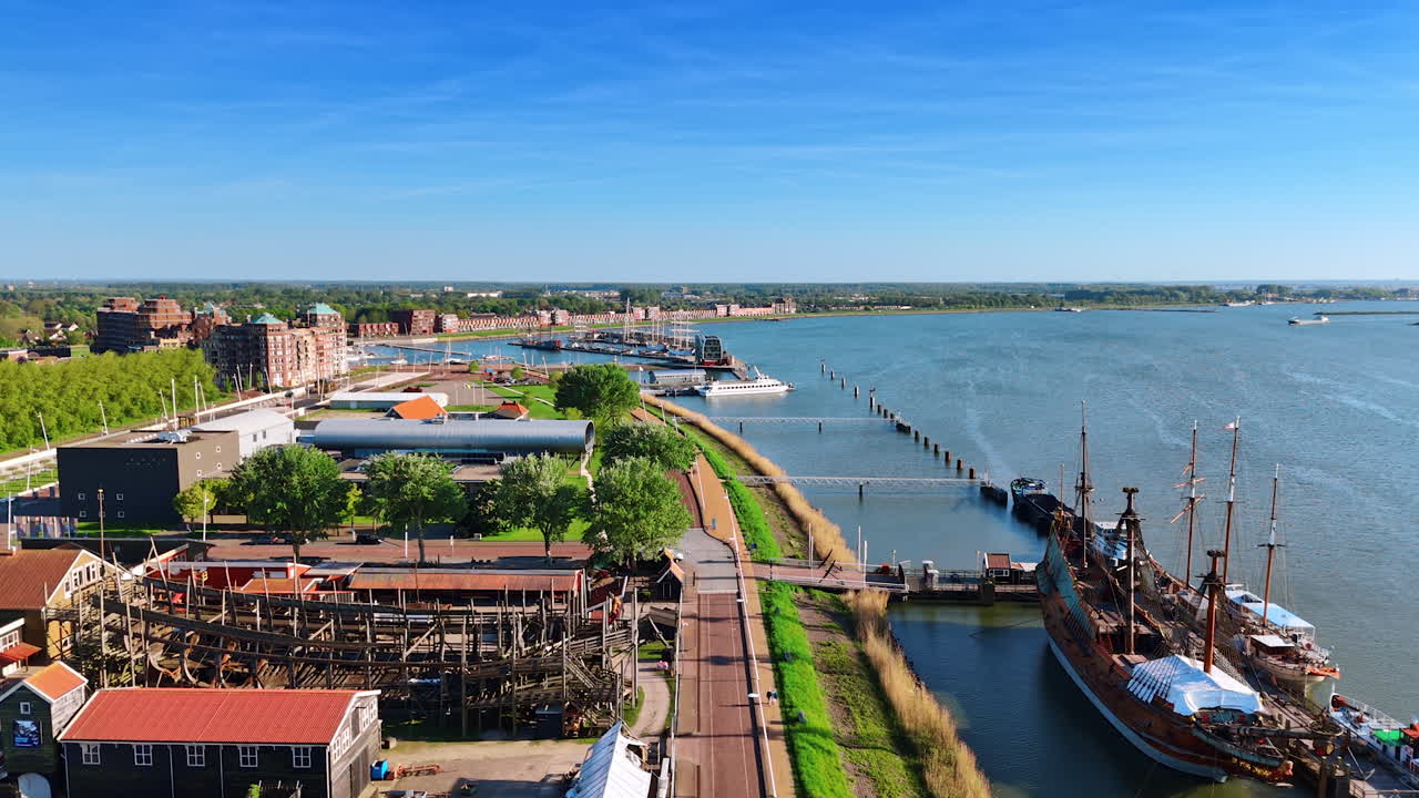 Historical museum Batavialand with ship reconstruction at the berth. Lakefront of Lelystad, the Netherlands. Aerial view.