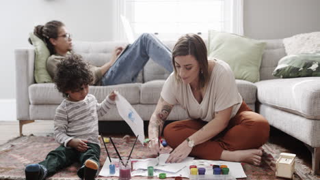 un niño pequeño pintando con su madre en casa