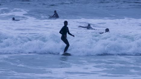 closeup of young pro female surfboarder rides a beautiful tube wave at golden sunrise