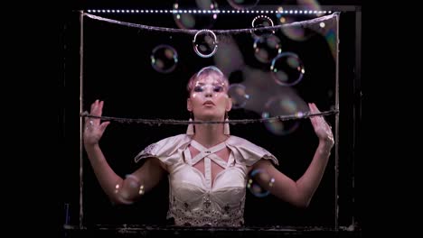 model girl does tricks with soap bubbles she blows a lot of bubbles towards the viewer