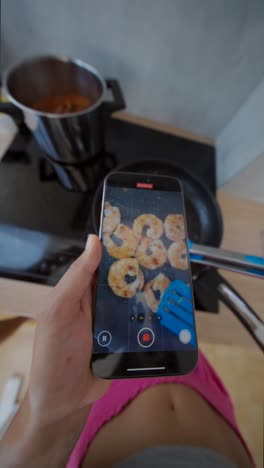 recording shrimp frying on a smartphone in the kitchen