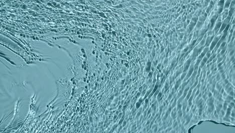 pure blue water with reflections sunlight in slow motion. water surface texture top view. motion clean swimming pool ripples and wave