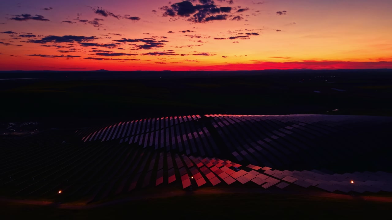Sunset view over solar panels in the countryside showing shadows and light with colors in the sky during evening