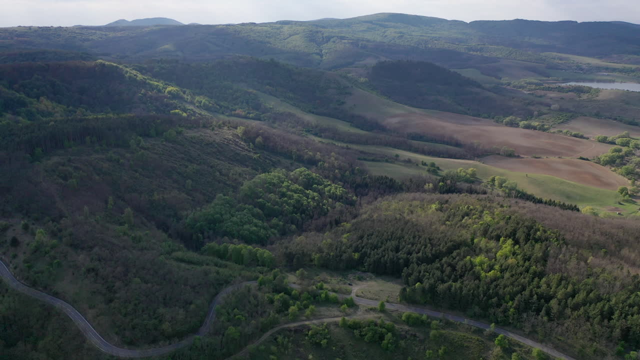 pequeña carretera que atraviesa hermosos paisajes con árboles y pendientes en hungría